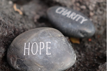 A rock with “Hope” written on it next to a rock with “Charity” written on it